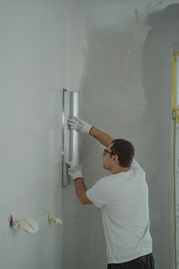 Maler beim Verspachteln einer Wand
